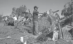  ?? MARK HENLE/THE REPUBLIC ?? Cody Payne (right) helps the Mahan family clean-up tornado damage Tuesday at their home in the Junipine Estates, north of Williams.