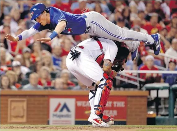  ?? — THE ASSOCIATED PRESS FILES ?? Chris Coghlan of the Toronto Blue Jays leaps over St. Louis Cardinals catcher Yadier Molina to score a run during a game in St. Louis on April 25. The play, which put Coghlan at risk of injury, quickly became a sensation on social media.