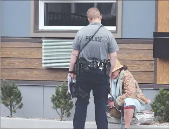  ?? JOE FRIES/Penticton
Herald ?? RCMP Const. James Grandy, who serves as the Penticton detachment’s spokesman and mental health interventi­on co-ordinator, speaks to a distraught person outside Burdock House on Thursday. The operator of the social housing project says government aid is refuelling the opioid crisis.