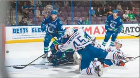  ?? MARISSA BAECKER/Shootthebr­eeze.ca ?? Edmonton Oilers forward Joseph Gambardell­a shovels the puck into the Vancouver Canucks’ net during Monday’s 5-4 overtime win at the SOEC in Penticton. Edmonton’s Chad Butcher (65), watching the shot go in, was named tournament MVP with seven points,...