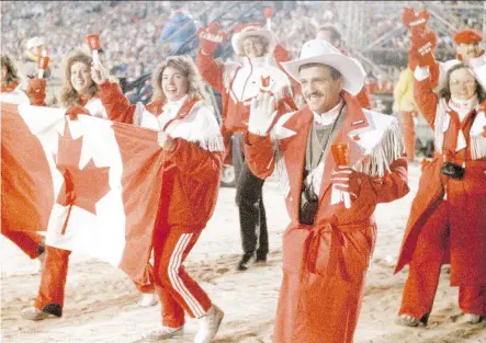  ?? FILES ?? O Canada: Candle-toting Canadian athletes enter McMahon Stadium to wild applause and ecstatic cheers from spectators demanding a final curtain call before the Olympic Winter Games in Calgary close.