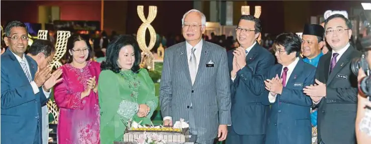  ?? [FOTO MOHD FADLI HAMZAH/BH] ?? Najib bersama Rosmah memotong kek pada Majlis Sambutan Aidilfitri JPM di PICC, Putrajaya, semalam.