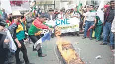  ??  ?? Manifestan­tes queman un féretro y un muñeco que simula ser el presidente boliviano Evo Morales, durante una protesta, ayer en La Paz.