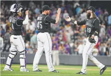  ?? Andy Cross, The Denver Post ?? Rockies right fielder Charlie Blackmon, right, congratula­tes new closer Scott Oberg and catcher Tony Wolters after defeating the Giants 5-4 at Coors Field on Friday night.