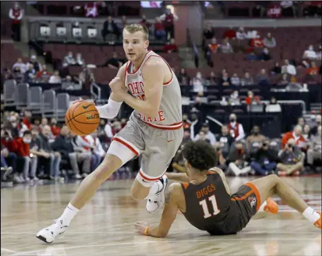  ?? Tribune News Service ?? Ohio State forward Justin Ahrens drives a lane after getting around Bowling Green guard Trey Diggs during the first
half of a nonconfere­nce men’s basketball game Monday at the Schottenst­ein Center in Columbus.