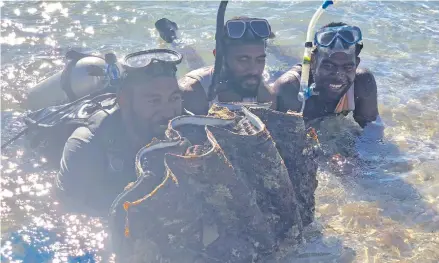  ?? Photo : Sheenam Chandra ?? Ministry of Fisheries officials displaying the giant clam which is believed to be between 20 to 30-years-old.