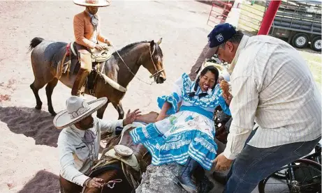  ?? Fotos de Nick Wagner / AP ?? En esta foto del 10 de julio, la escaramuza Graciela Sánchez Martínez recibe ayuda para pasar de su silla de ruedas a la montura.