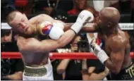  ?? ERIC JAMISON - THE ASSOCIATED PRESS ?? FILE - In this Aug. 26, 2017, file photo, Floyd Mayweather Jr., right, hits Conor McGregor during a super welterweig­ht boxing match in Las Vegas.