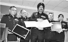 ??  ?? Bukit Aman Commercial Crime Investigat­ion Department director Datuk Amar Singh Ishar Singh (center) showing the confisated items at a press conference. - Bernama photo