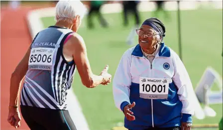  ??  ?? Triumphant run: Kaur celebratin­g after competing in the 100m sprint in the 100+ age category at the World Masters Games at Trusts Arena in Auckland. — AFP