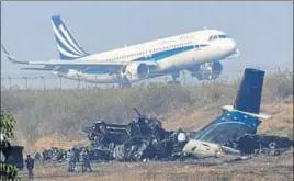  ?? AFP ?? An airplane takes off near the wreckage of the USBangla Airlines plane that crashed on Monday.