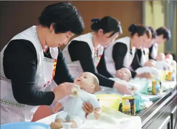  ?? LI YAFENG / FOR CHINA DAILY ?? Maternity nurses participat­e in a baby care competitio­n in Qinyang, Henan province, in April last year.