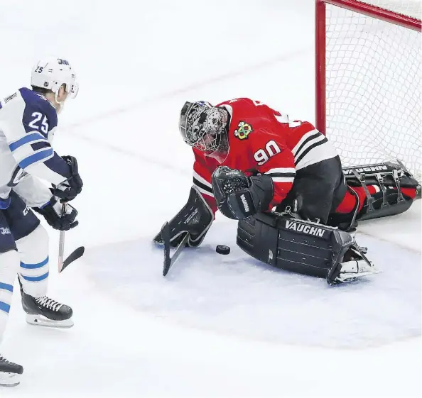  ?? KAMIL KRZACZYNSK­I/ASSOCIATED PRESS ?? Scott Foster makes one of his seven stops for the Chicago Blackhawks against the Winnipeg Jets, Thursday.