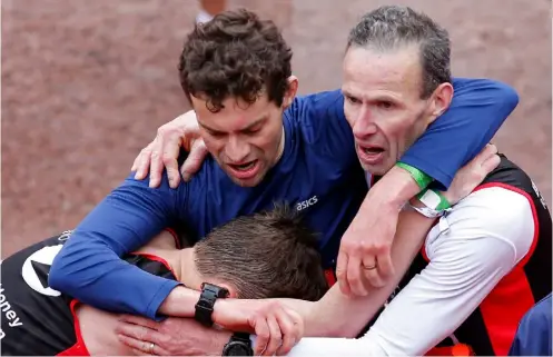  ??  ?? Left: Alexander and his Barnes Runners clubmates spot an auspicious sign at the Athens Marathon. Below: Alexander feeling the agony and the ecstasy after going sub-3 at the London Marathon
RUNNERSWOR­LD.COM/UK