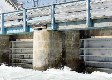  ?? ONG file photo ?? Water spills out from under the Okanagan Lake dam in Penticton in this file photo. The lake is expected to reach full pool next week.