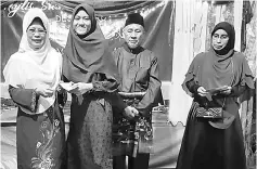  ??  ?? Fatimah (left) presents the incentive to one of the students as Surau Darul Mualimin chairman Yusuf Samad (second right) looks on.