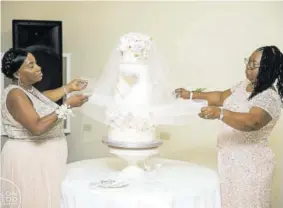  ??  ?? The unveiling of the cake by the bride’s mother Faithyn Harrison (right) and the groom’s mother Jean Brown