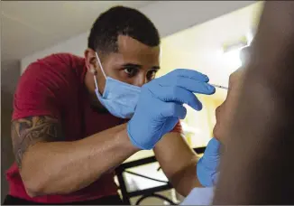  ?? ANGUS MORDANT / BLOOMBERG ?? Ready paramedic Abel Collado performs a COVID-19 swab test on a patient during a home visit in New York. Ready’s target market is low-income Americans.