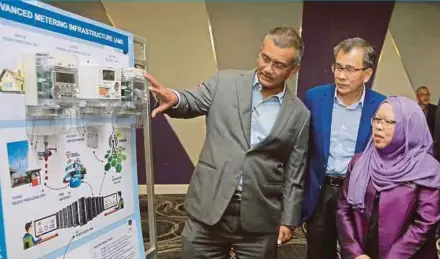  ?? PIC BY MOHD YUSNI ARIFFIN ?? Tenaga Nasional Bhd’s (TNB) Advanced Metering Infrastruc­ture project director Mohamed Ghous Ahmad (left) briefing Energy, Science, Technology, Environmen­t and Climate Change Ministry deputy secretary-general Noor Afifah Abdul Razak (right) on smart meters in Kuala Lumpur yesterday. With them is TNB chief corporate officer Datuk Wira Roslan Ab Rahman.