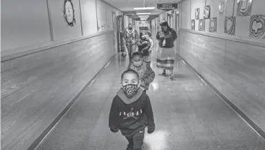  ?? PROVIDED BY ERIK PETERSEN/THE HECHINGER REPORT ?? Teacher Shari Daniels, right, walks with her kindergart­en class at Poplar Elementary School in mid-March. Daniels attended the school herself while growing up on the neighborin­g Fort Peck Reservatio­n.