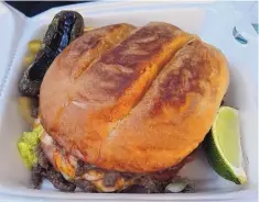  ??  ?? The birrieria makes a jumbo torta with cheese, diced onions and the meat of your choice.