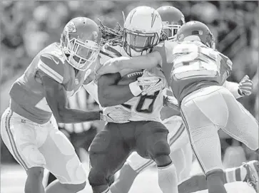  ?? Robert Gauthier Los Angeles Times ?? MELVIN GORDON of the Chargers is stopped by Kansas City Chiefs defenders in the first half, in which the running back scored on an 11-yard run in L.A.’s 24-10 loss at StubHub Center.