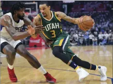  ??  ?? Utah Jazz guard George Hill (right) drives past Los Angeles Clippers center DeAndre Jordan during a game Sunday in Los Angeles. AP PHOTO