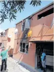  ?? ?? NEIGHBOURS outside the burnt flat in Phoenix where five people lost their lives. Yesterday Kista Sergie Chetty appeared in the Durban High Court facing five counts of murder, six counts of attempted murder and an arson charge. | ZAINUL DAWOOD