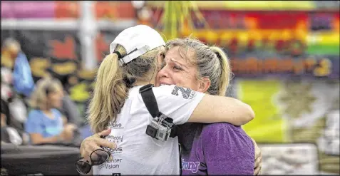  ?? AP ?? Runners Randa Black (left) and Elizabeth Anne-Noles cry after stopping in front of the Pulse nightclub during the CommUNITYR­ainbowRun 4.9K road race Saturday in Orlando, Fla. The massacre at the club left 49 people dead.