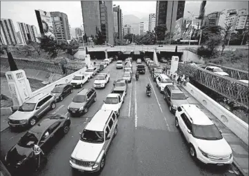  ?? ARIANA CUBILLOS/AP ?? Vehicles line up in May near a gas station in Caracas, Venezuela. Drivers could wait days in line to fill up their gas tanks.