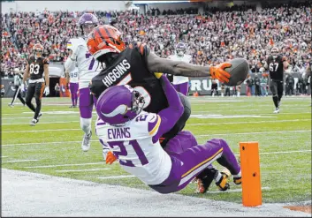  ?? Carolyn Kaster
The Associated Press ?? Bengals wide receiver Tee Higgins reaches past Vikings cornerback Akayleb Evans to score with 39 seconds left in regulation in Cincinnati’s overtime win Saturday.