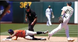  ?? JANE TYSKA — STAFF PHOTOGRAPH­ER ?? The Astros' Jose Siri is safe on a stolen base attempt as A's second baseman Sheldon Neuse recovers the throw during the fifth inning of Monday's game at the Coliseum.