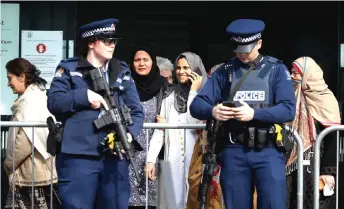  ?? — AFP photo ?? Police keeping watch as survivors and relatives of victims of the 2019 Christchur­ch mosque attacks leave the Christchur­ch High Court building during the first day of Tarrant’s sentencing hearing in Christchur­ch.