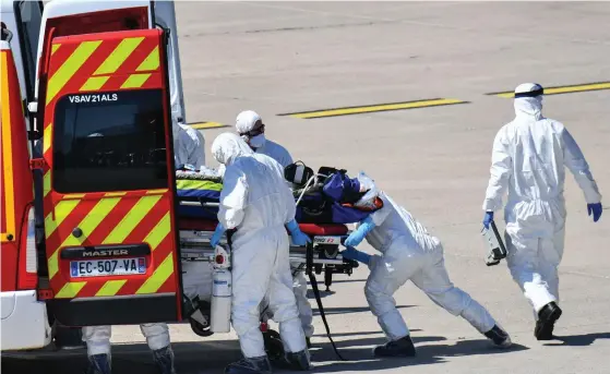  ?? FOTO: PASCAL GUYOT/LEHTIKUVA–AFP ?? Sjukvårdsp­ersonal flyttar en covid-patient som anlänt med helikopter till en ambulans i Nimes. Detta är nödvändigt bara för att sjukhusen och vårdkapaci­teten i östra Frankrike är överbelast­ade.