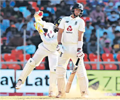  ??  ?? Dust bowl: The England captain, Joe Root, is nonplussed by a wicked, turning Axar Patel delivery which is well taken by Rishabh Pant