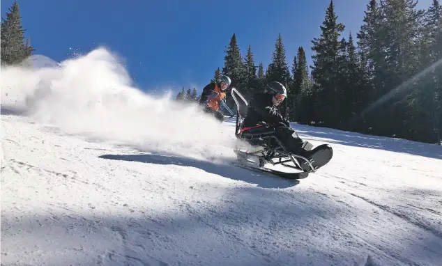  ?? COURTESY JJ JOSHUA SQUIRES ?? Mike Adams skis at Ski Santa Fe in 2016, tethered by Adaptive Sport Program ski instructor Bruce Hopper. ‘There’s nothing like it,’ Adams said of downhill skiing.