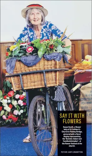  ??  ?? Susan South, a flower lady at St Cuthbert’s Church in Pateley Bridge, pictured with a floral display representi­ng the ‘Butcher, Baker and Candlestic­kmaker’, at the flower festival at the church.