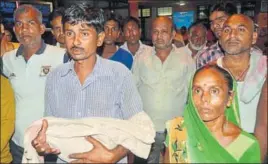  ?? SUSHIL KUMAR/HT ?? A man holding a child’s body at BRD Medical College in Gorakhpur on Friday.