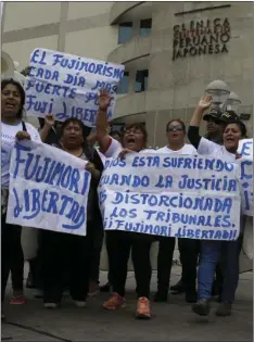  ??  ?? A small group of supporters of former President Alberto Fujimori shout slogans outside the clinic where the jailed leader was hospitaliz­ed, in Lima, Peru on Tuesday. Peru’s President Pedro Pablo Kuczynski granted a medical pardon to the jailed former...
