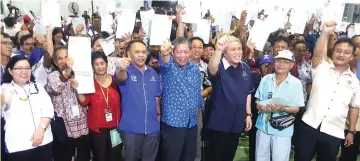  ??  ?? Awang Tengah (front, third right), Nogeh on his right and Henry (front, fourth left) join the landowners in a group photo after the presentati­on of titles.