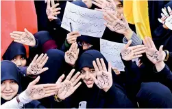  ?? –AFP ?? Iranian girls take part in a demonstrat­ion outside the former US embassy in the Iranian capital Tehran on Sunday marking the anniversar­y of its storming by student protesters that triggered a hostage crisis in 1979. Farsi writing on their palms praising the supreme leader Ayatollah Ali Khamenei.