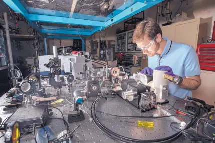  ?? COURTESY OF RANDY MONTOYA/SANDIA LABS ?? Sandia National Laboratori­es optical engineer Michael Goldflam sets up equipment to load and characteri­ze a new nanoantenn­a-enabled detector.