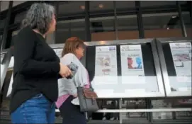  ?? MANUEL BALCE CENETA — THE ASSOCIATED PRESS ?? Newseum visitors browse newspaper front pages displayed outside the museum in Washington, Monday. There’s substantia­l agreement on what Americans want from the news media and what journalist­s want to report, according to a pair of studies that also...