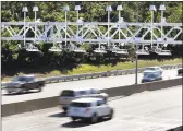  ?? Associated Press ?? Cars pass under toll sensor gantries hanging over the Massachuse­tts Turnpike in Newton, Mass.