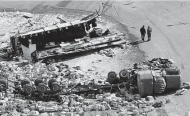  ?? The Canadian Press ?? The wreckage of a bus, top, and a tractor-trailer is strewn across a highway on Saturday, the day after the semi T-boned the bus, which was carrying a junior hockey team. Fifteen on the bus were killed.