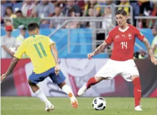  ?? AP ?? Lucha. Philippe Coutinho, de Brasil, busca el balón ante Steven Zuber, de Suiza, en el juego de ayer.