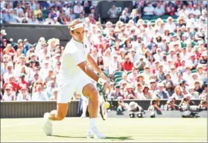  ?? AFP ?? Roger Federer returns to Dusan Lajovic during their men’s singles first round match on the first day of the 2018 Wimbledon Championsh­ips on Monday.