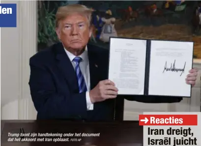  ?? FOTO AP ?? Trump toont zijn handtekeni­ng onder het document dat het akkoord met Iran opblaast.