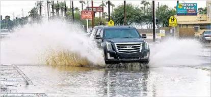  ?? RANDY HOEFT /THE YUMA SUN VIA AP ?? A vehicle drives on a flooded street Sunday following a rain storm in Yuma, Ariz. Tropical Storm Rosa neared Mexico’s Baja California on Monday, spreading heavy rains that were projected to drench the U.S. Southwest.