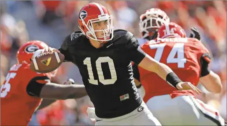  ??  ?? File, John Bazemore / The Associated Press Georgia quarterbac­k Jacob Eason is one of three players Georgia coach Kirby Smart could select to lead the Bulldogs on the field in their first game.